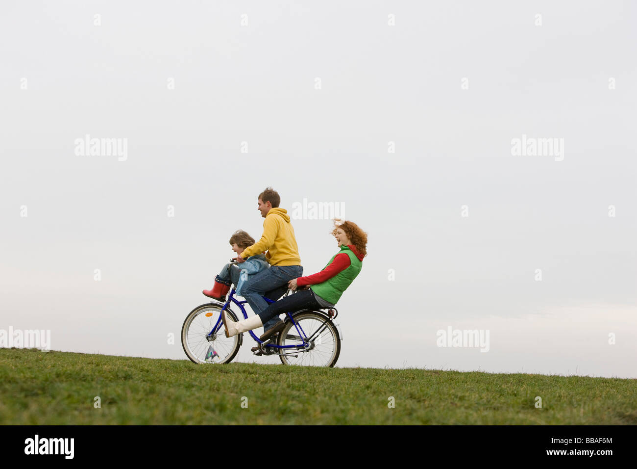 Eine junge Familie, die zusammen mit dem Fahrrad fahren Stockfoto