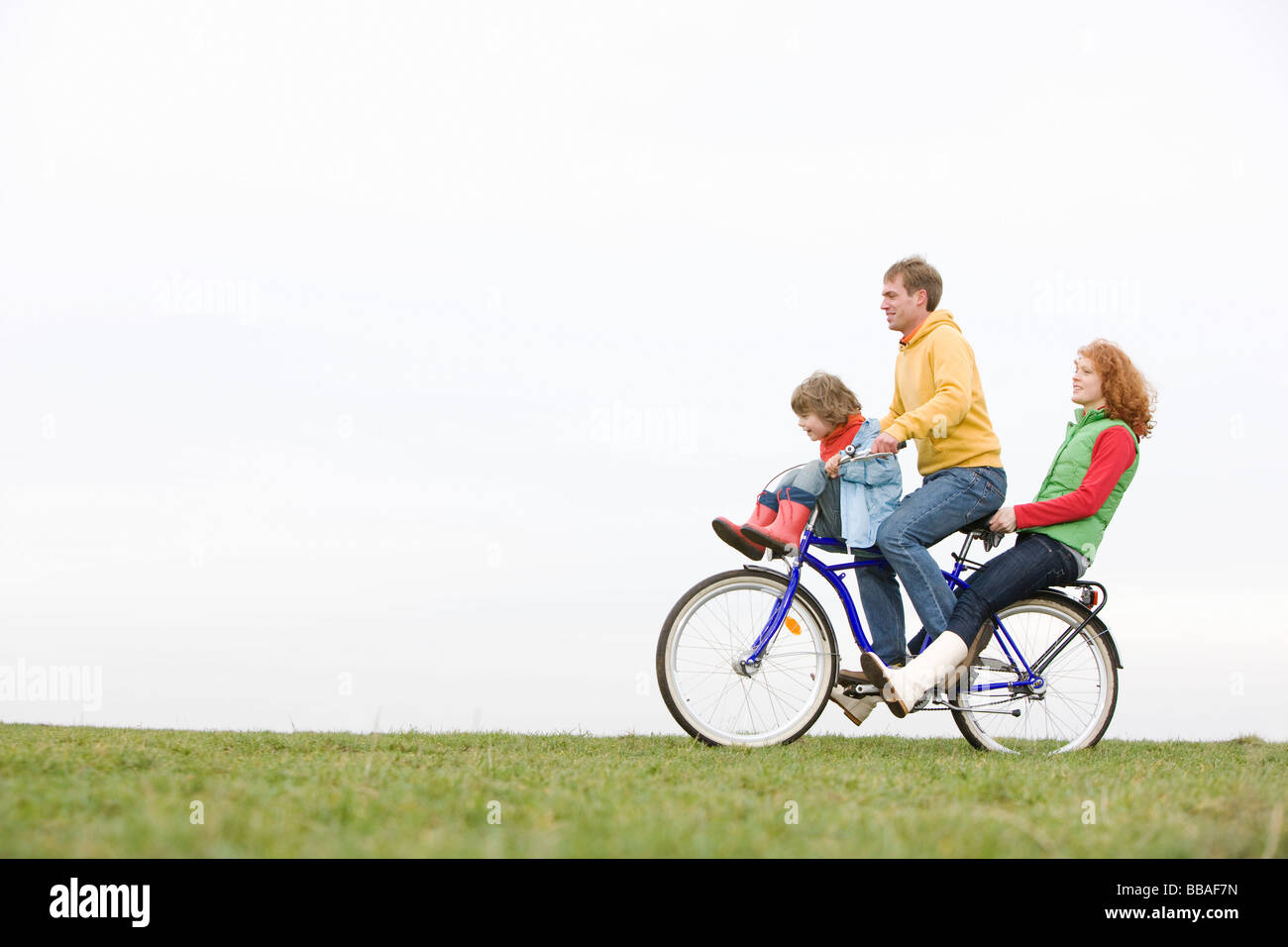 Eine junge Familie, die zusammen mit dem Fahrrad fahren Stockfoto