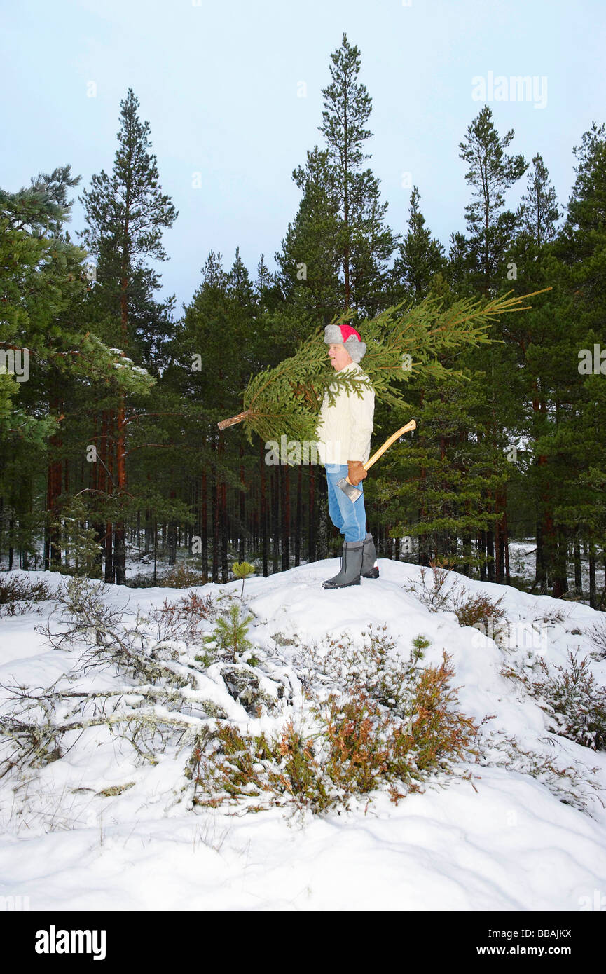 Mann mit Weihnachtsbaum im Wald Stockfoto