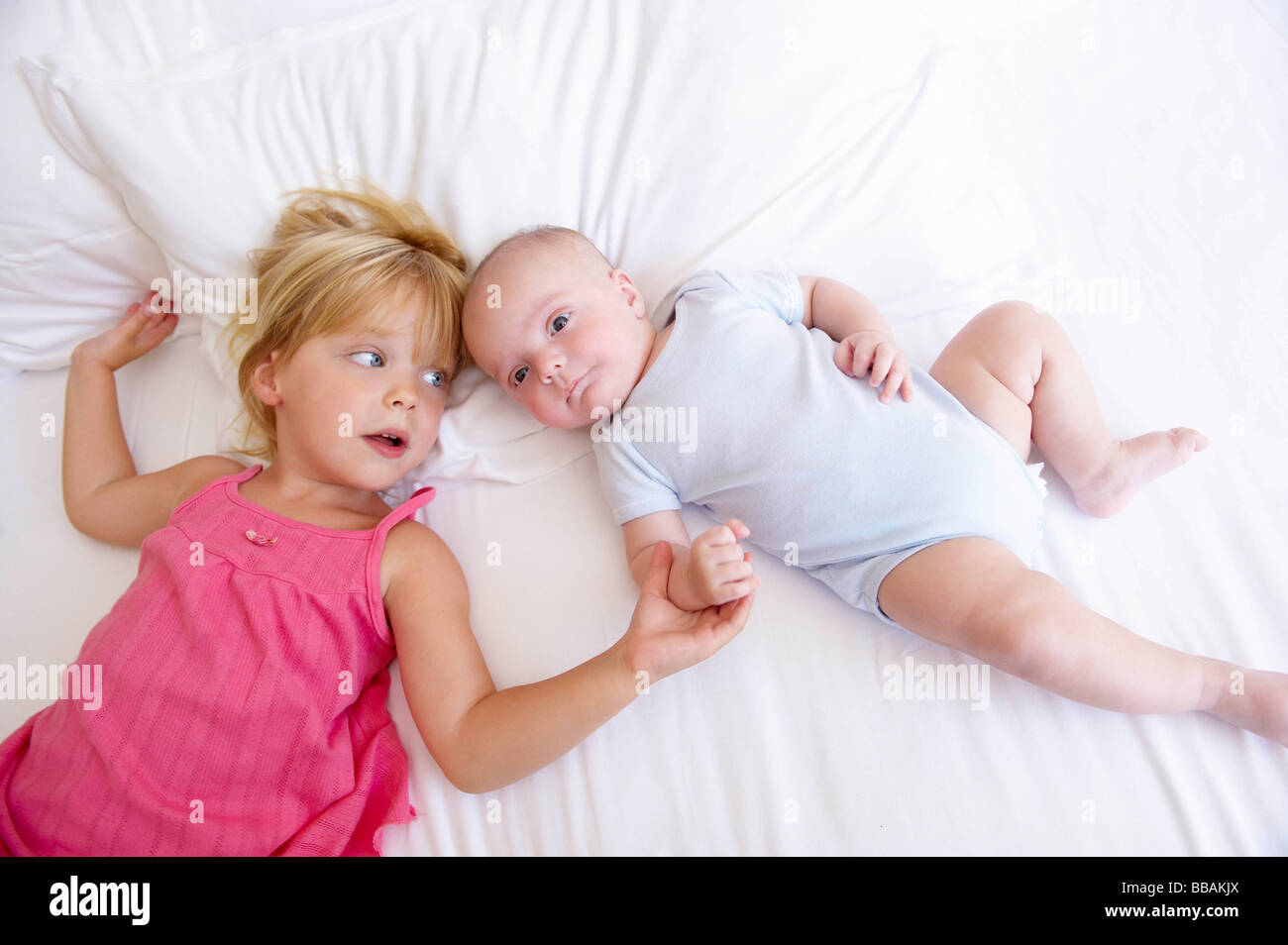 Mädchen mit ihrem kleinen Bruder im Bett Stockfoto