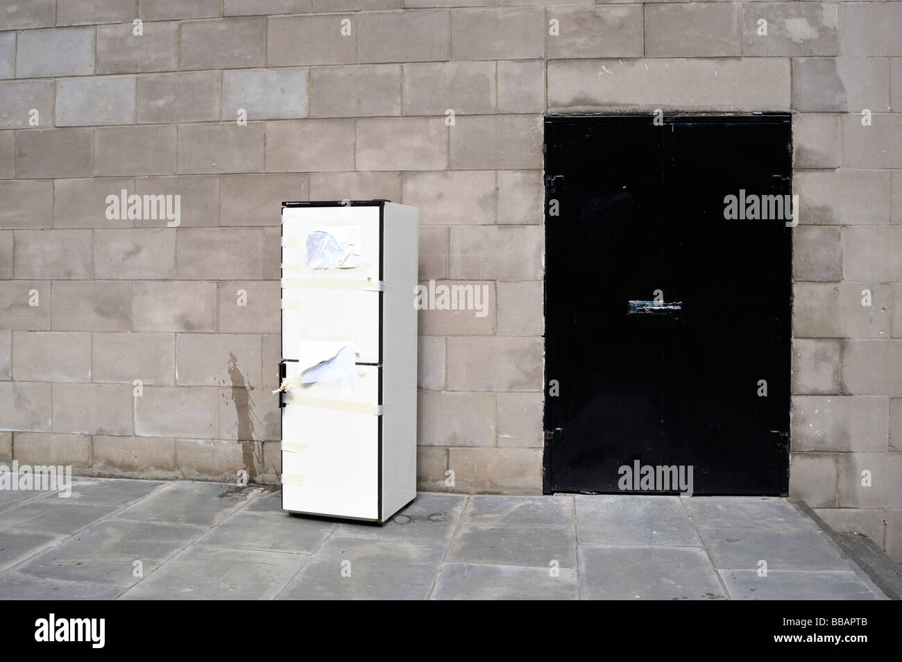 Ein Kühlschrank neben einem schwarzen Tor Stockfoto