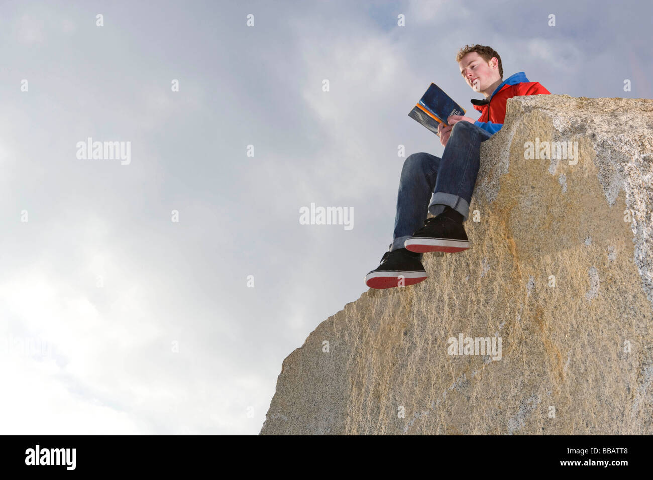 Mann liest auf Berggipfel Stockfoto