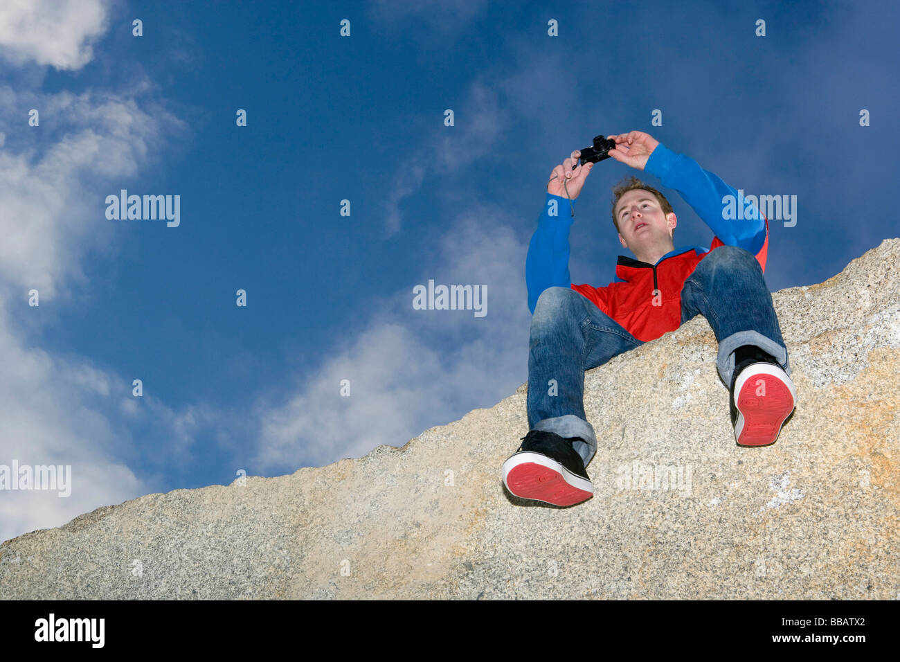 Mann unter Bild auf Berggipfel Stockfoto