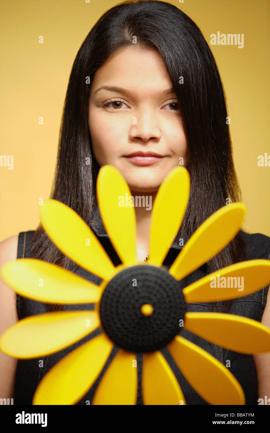 Junge Frau vor gelbem Hintergrund, Pin-Rad vor ihr Stockfoto