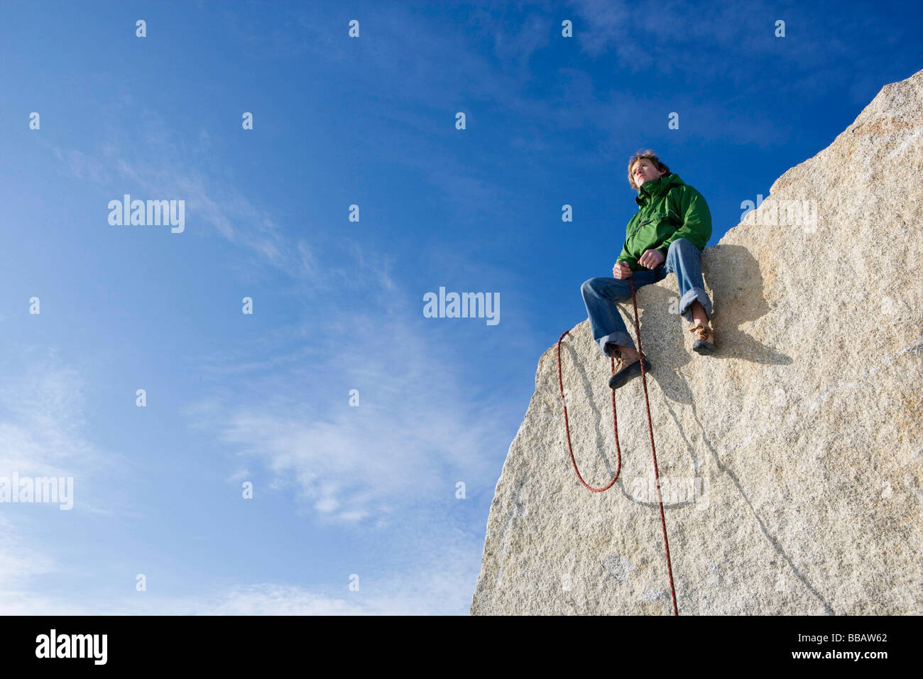 Bergsteiger am Gipfel sitzen Stockfoto