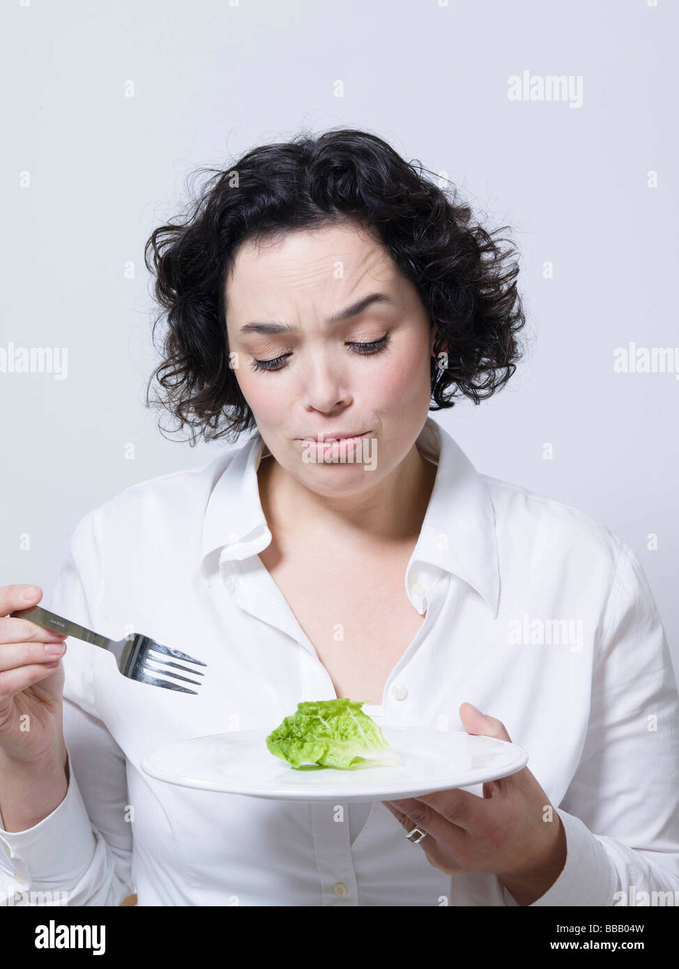 Frau betrachten ein Blatt Salat Stockfoto