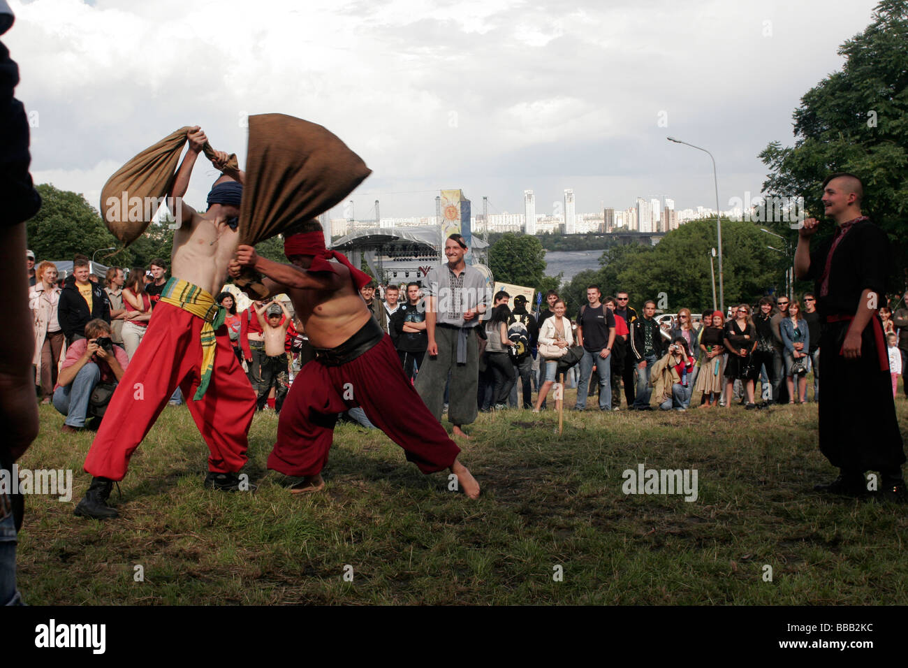 Ukrainisches traditionelles kosakenspiel von Männern mit verbundenen Augen und Heusäcken, die sich gegenseitig bis an die Grenzen der Ausdauer testen Stockfoto