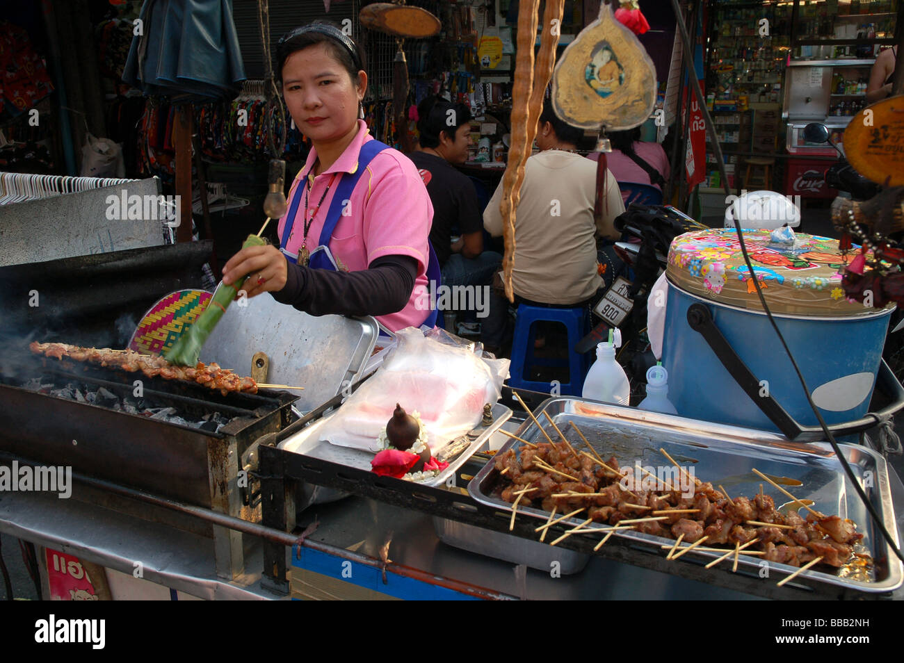 Thai Lady, Verkauf von gegrilltem Hähnchen-Sticks in Khao San Road, Bangkok, Thailand Stockfoto