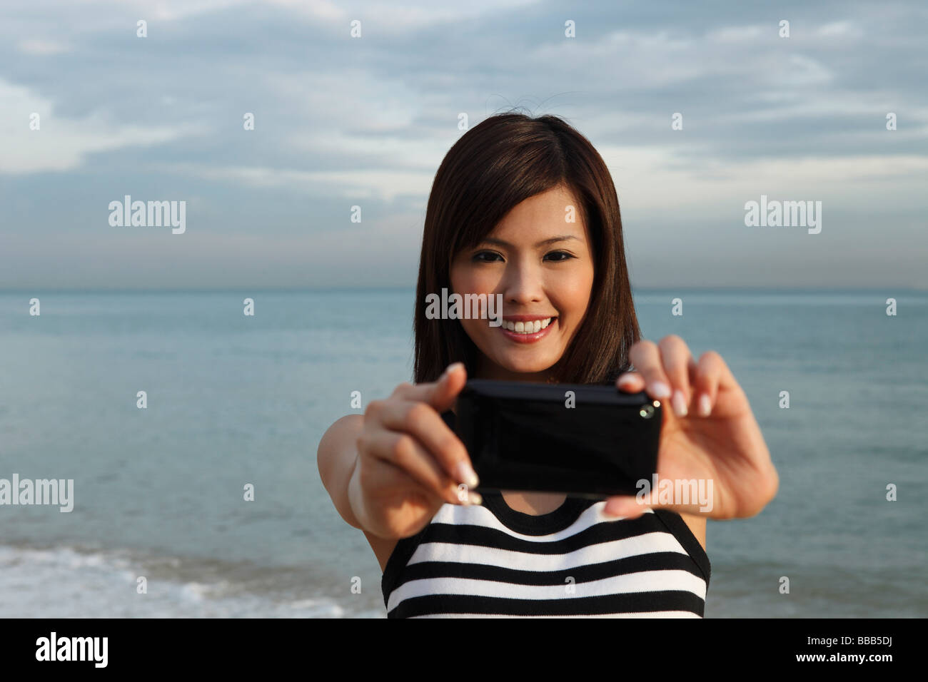 Junge Frau lächelnd durch Mitte des Innenrohres Stockfoto