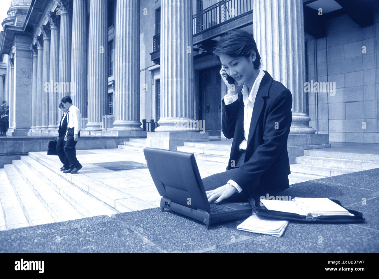 Weibliche Führungskraft mit Laptop und Handy Stockfoto