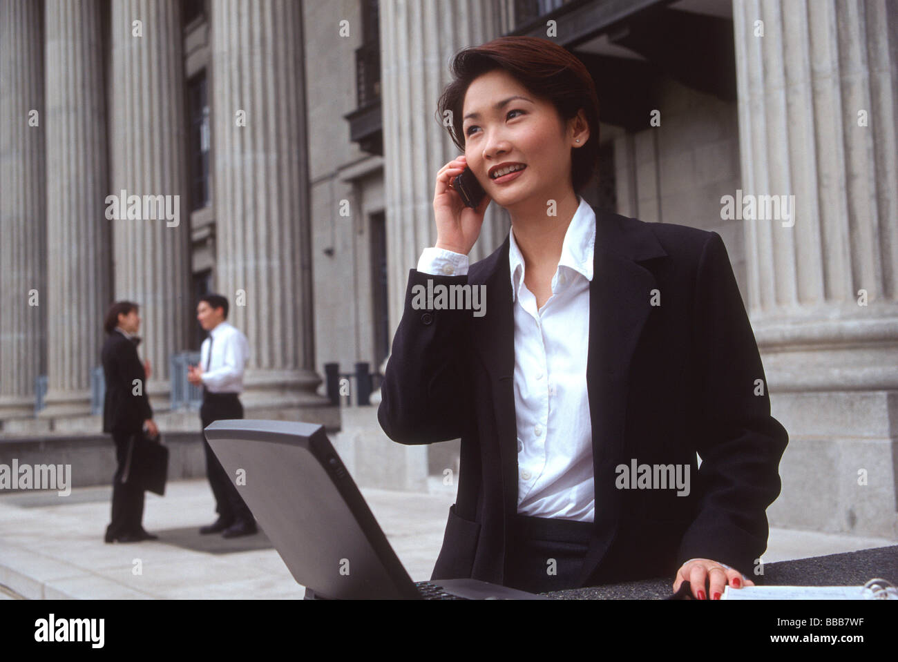 Weibliche Führungskraft mit Laptop und Handy Stockfoto