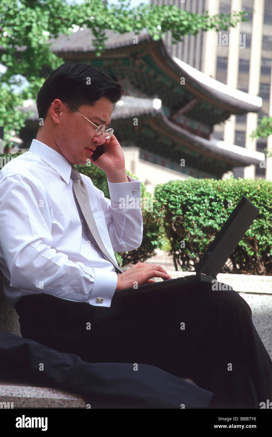 Männliche Führungskraft mit Laptop und Handy in Seoul, Korea Stockfoto