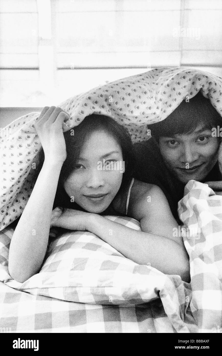Mann und Frau im Bett unter Blatt, Porträt Stockfoto