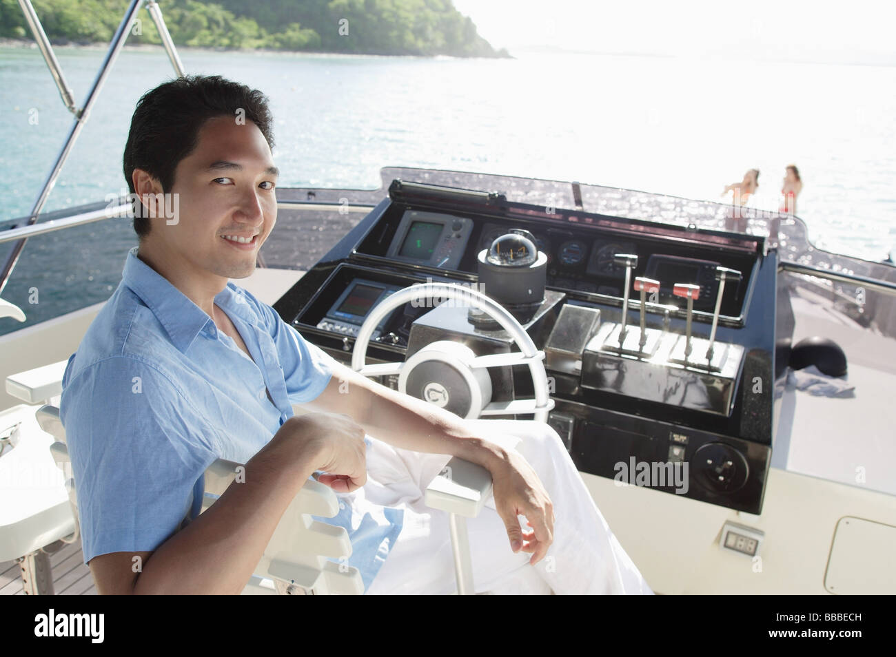 Mann sitzt an der Spitze der Yacht, Blick in die Kamera Stockfoto
