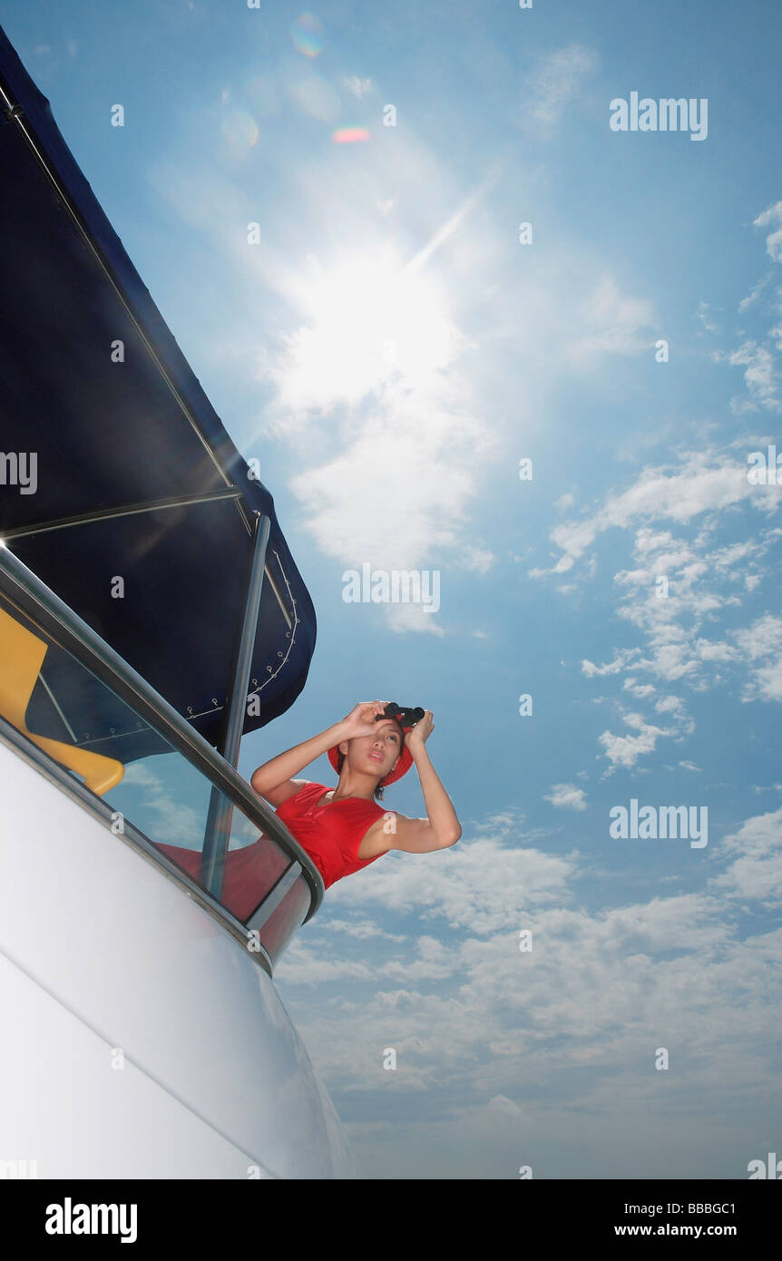 Junge Frau mit dem Fernglas auf Yacht, Blick in Ferne Stockfoto