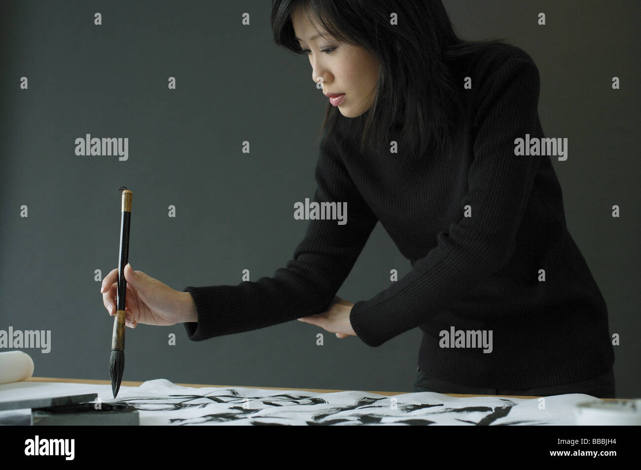 Junge Frau Malerei chinesische Kalligraphie Stockfoto