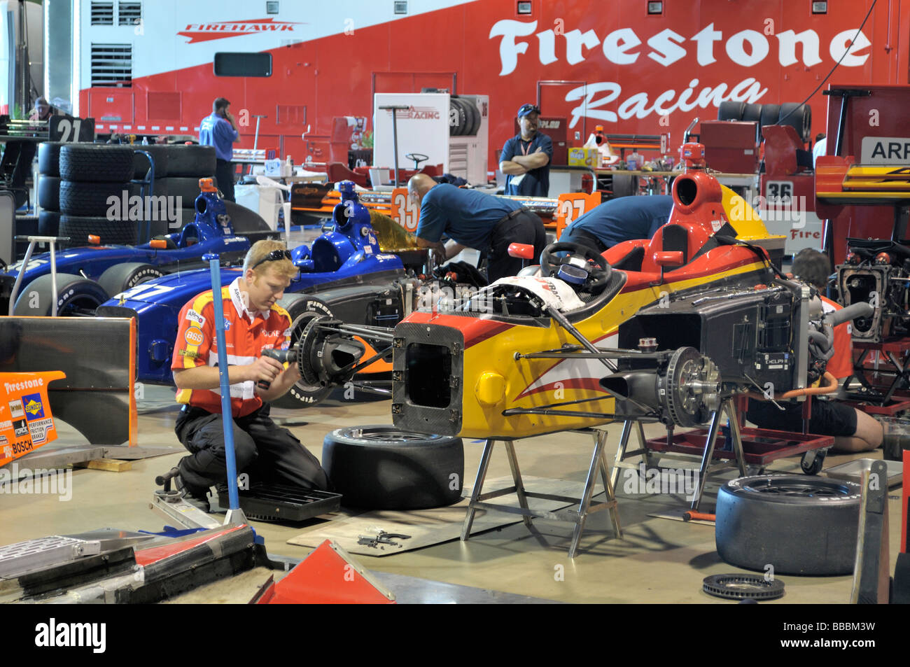 Mechaniker bei der Arbeit auf bunten Indy-Rennwagen Stockfoto