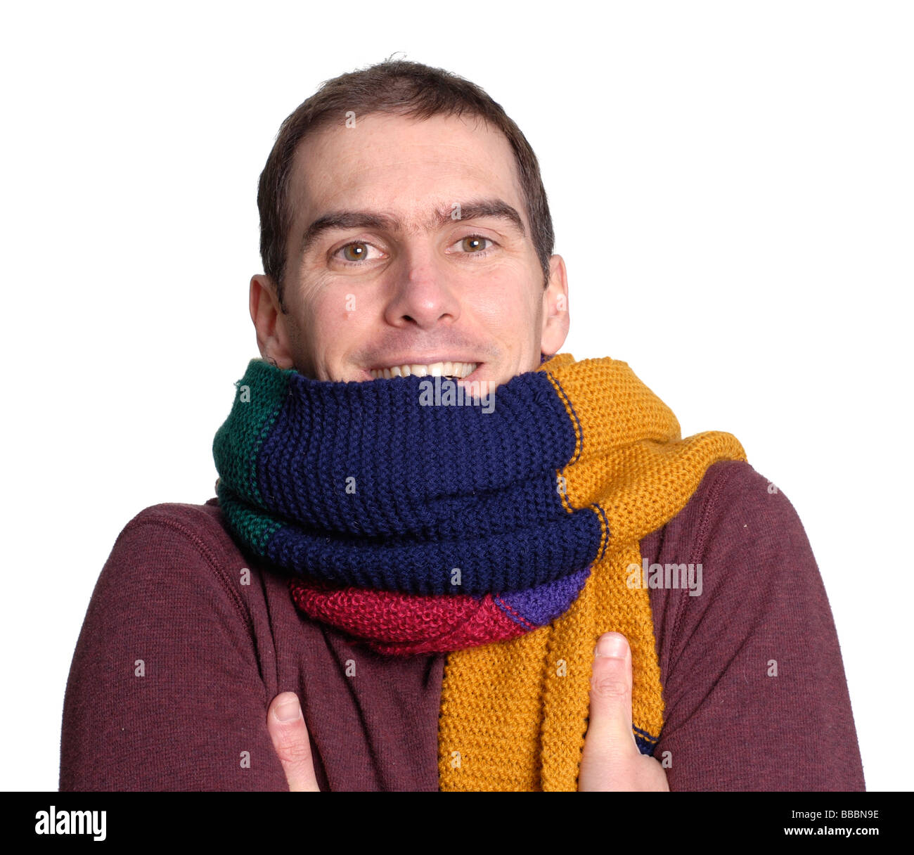 Junger Mann, Gefühl der Kälte trägt einen großen bunten Schal Stockfoto