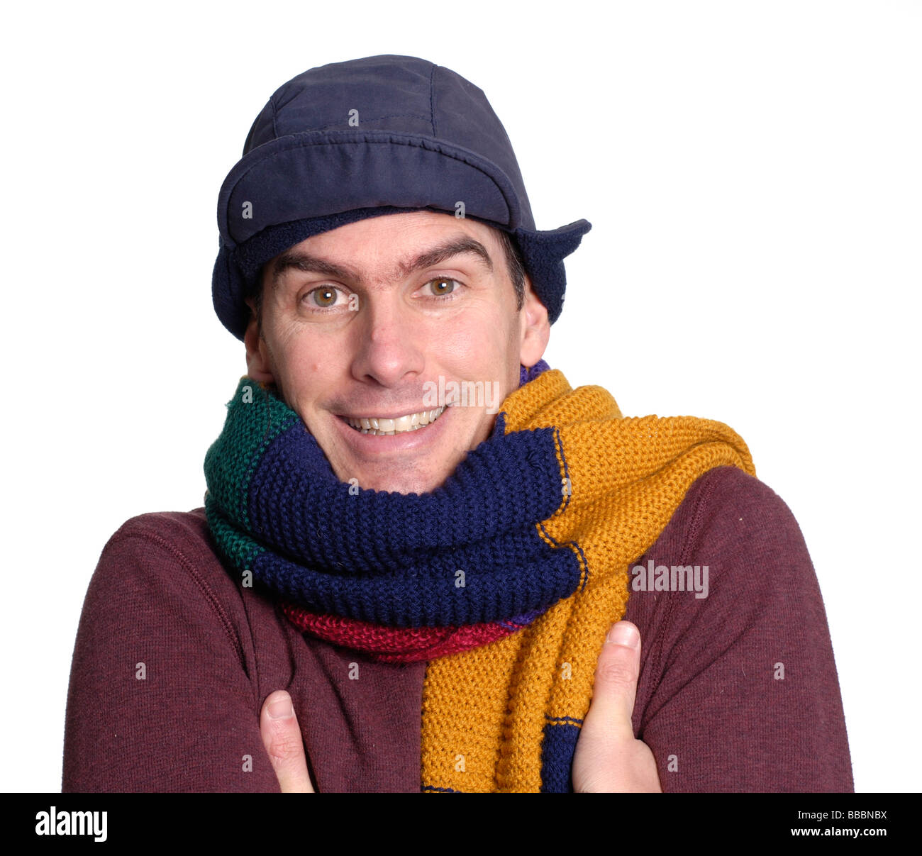 Junger Mann, Gefühl der Kälte trug einen großen bunten Schal und Mütze Stockfoto