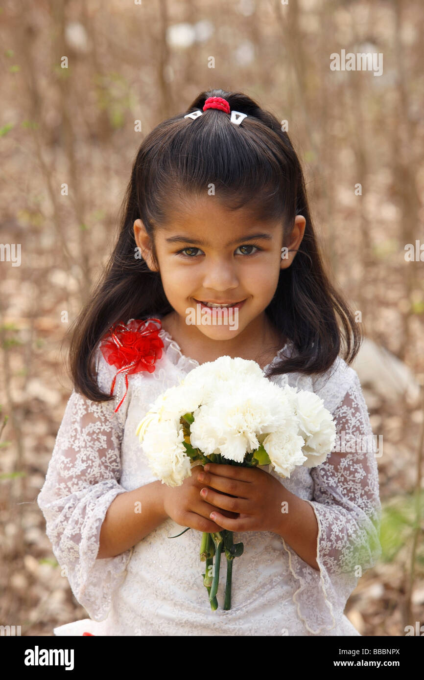 Kleines Mädchen im weißen Kleid hält Strauß (Hochformat) Stockfoto