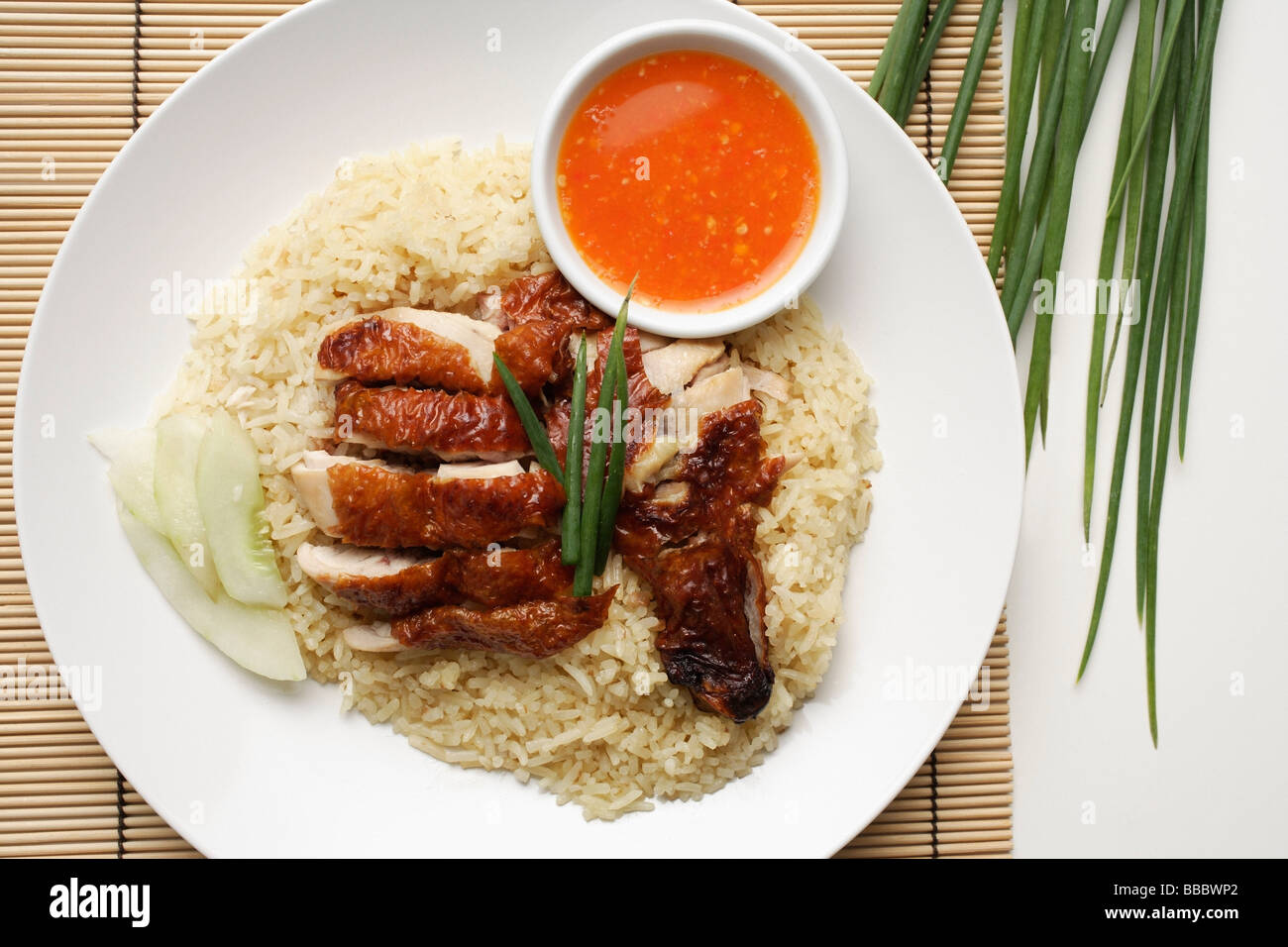 Huhn mit Reis mit Chili-Sauce auf der Seite auf weißen Teller Stockfoto