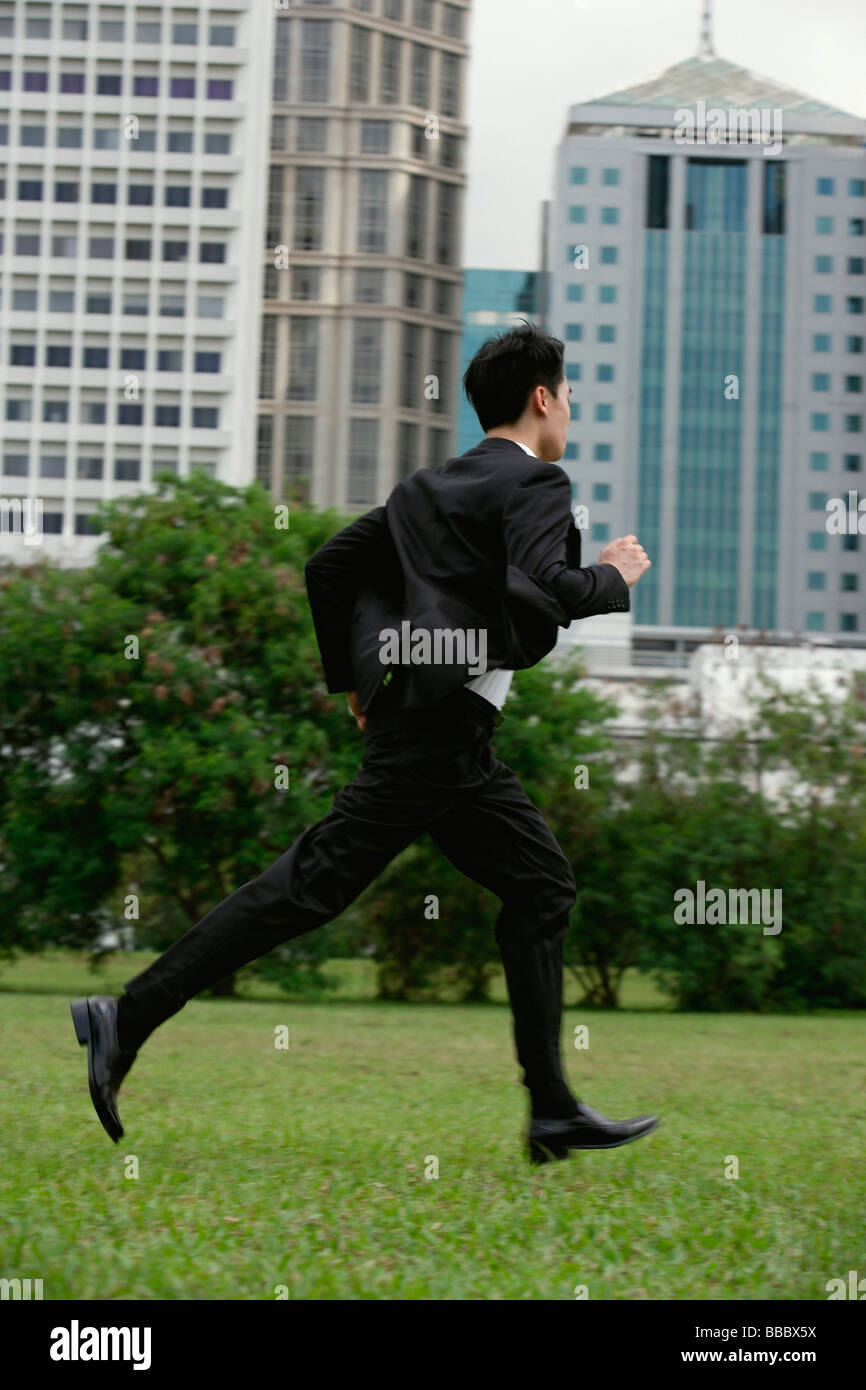 Geschäftsmann, läuft durch den park Stockfoto