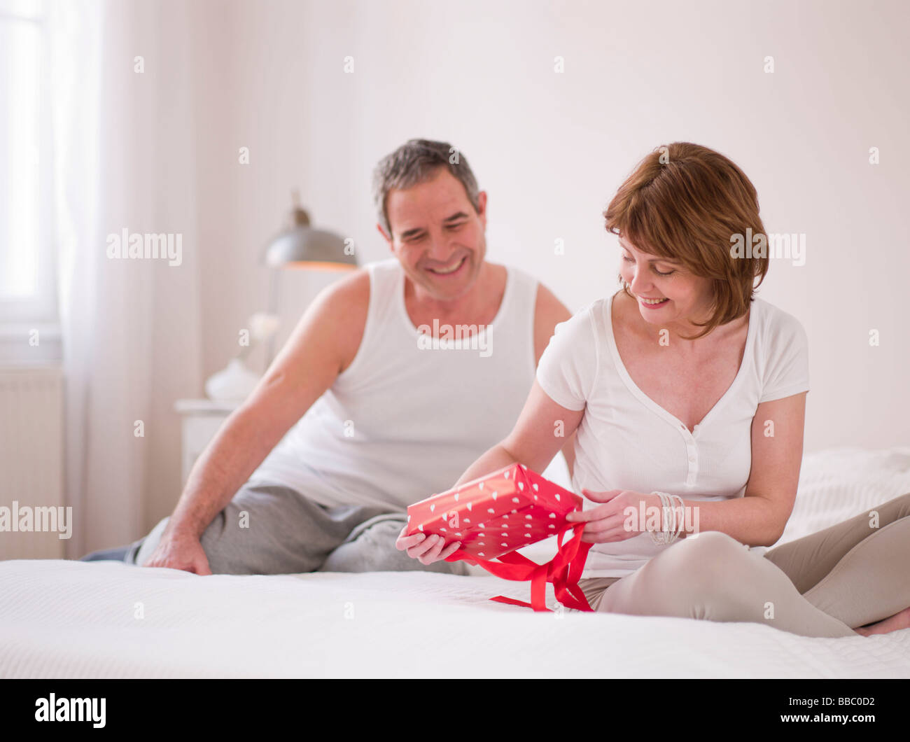 Ältere paar im Bett mit Geschenken Stockfoto