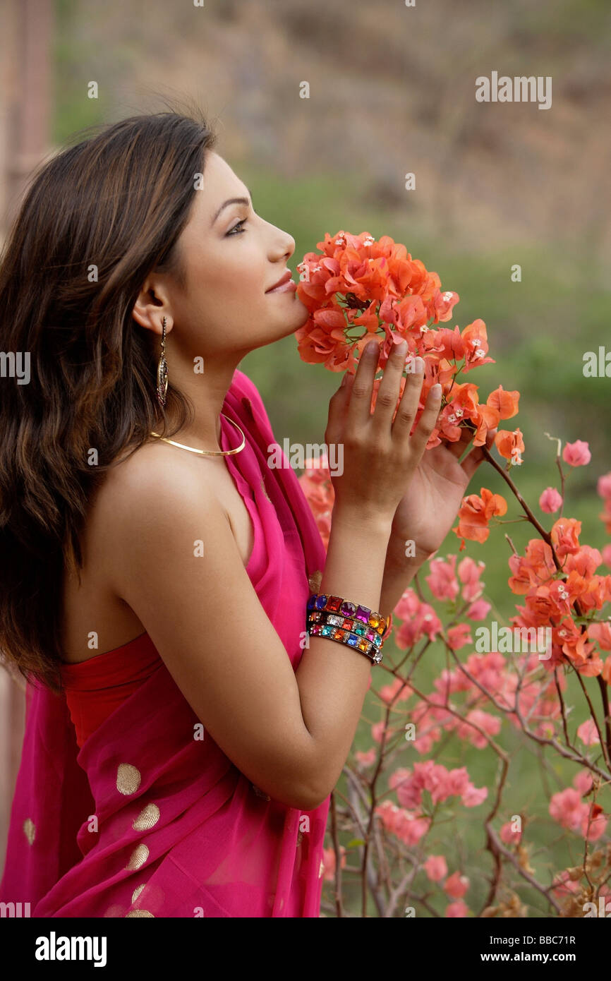 junge Frau im Sari, Blumen riechen Stockfoto