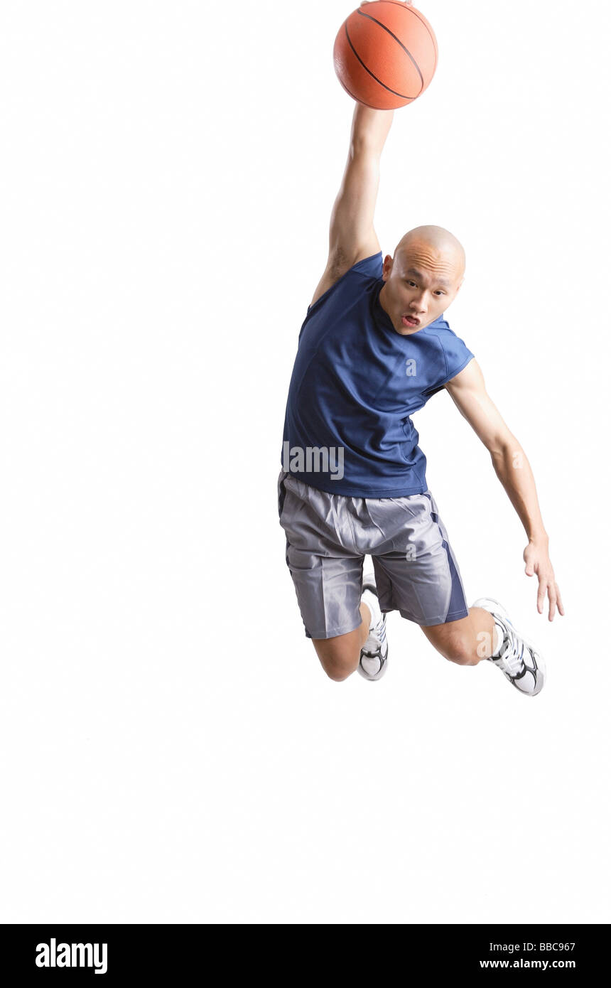 Junger Mann, der eine Slam-Dunk Basketball Stockfoto