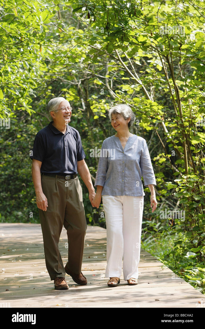 Älteres Paar zu Fuß durch den Park, Hand in Hand Stockfoto