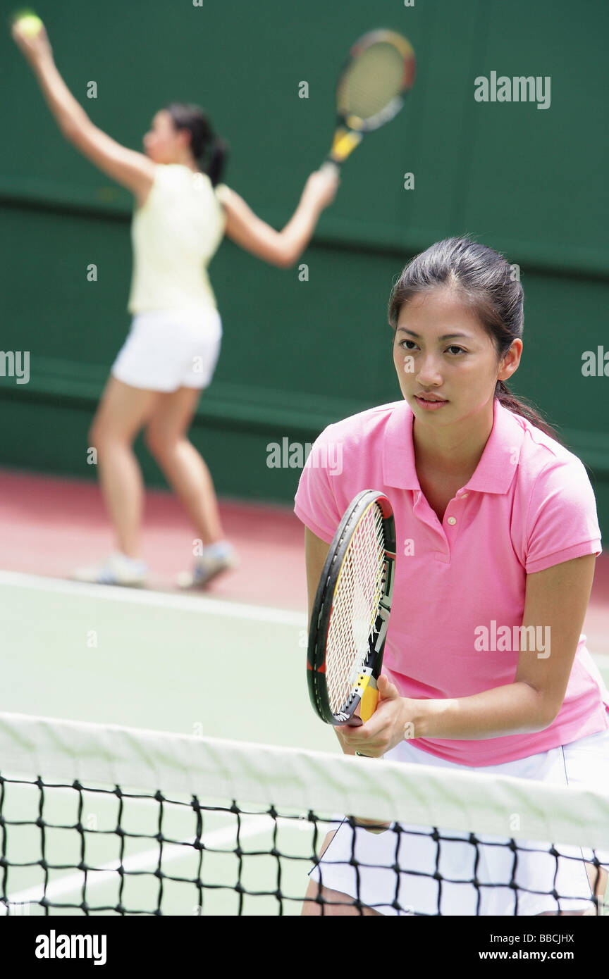 Zwei Frauen spielen Tennis, Mixed-Doppel Stockfoto