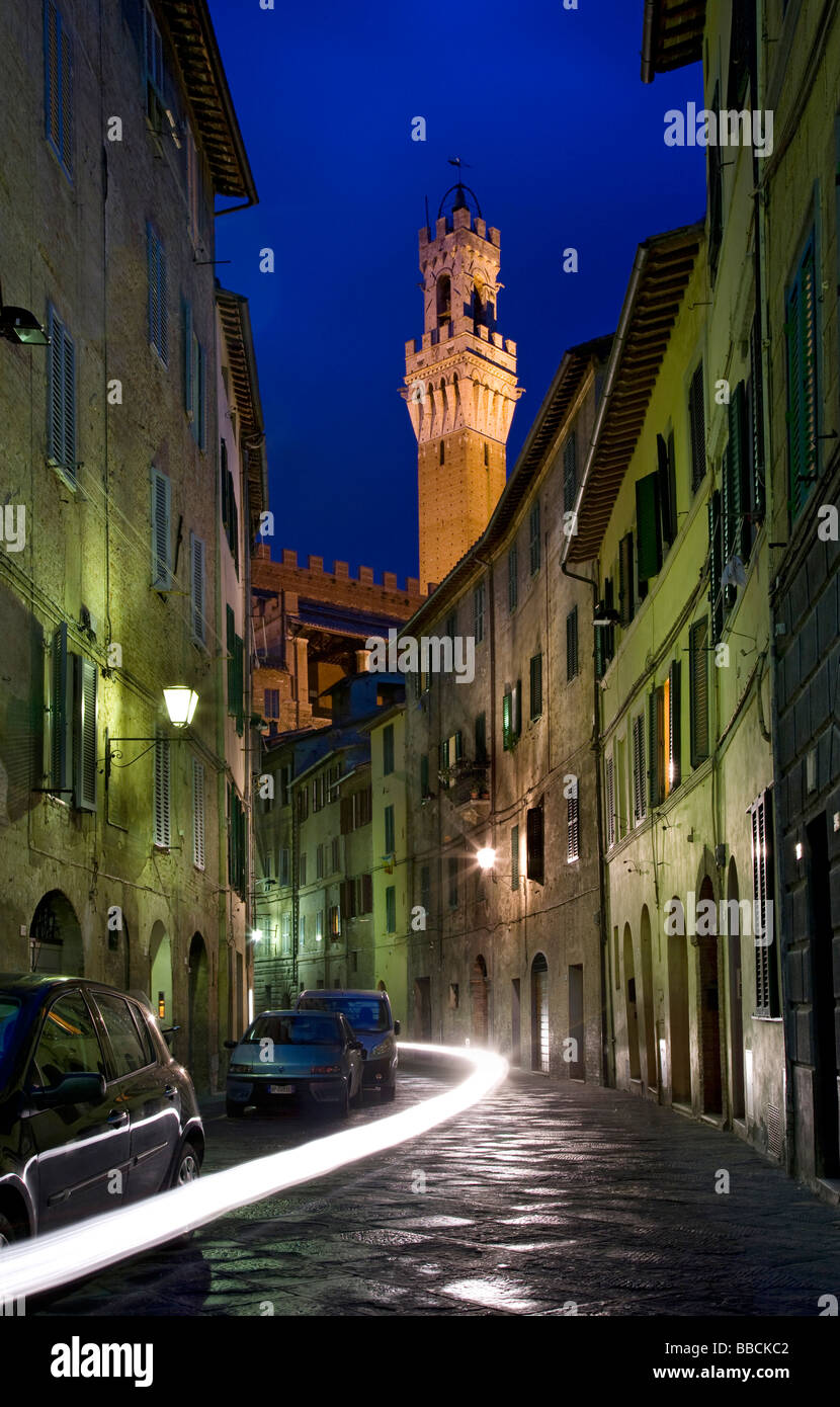 Nachtansicht auf kleine Straße zum Turm Torre del Mangia in Siena, Toskana, Italien Stockfoto