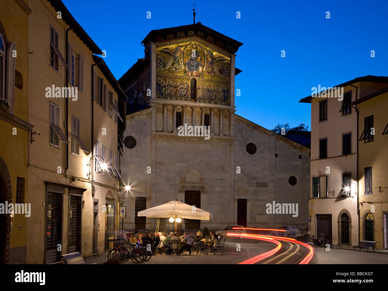 Nachtansicht des Straßencafé und Fassade der Basilica Di San Frediano, Lucca, Toskana, Italien Stockfoto