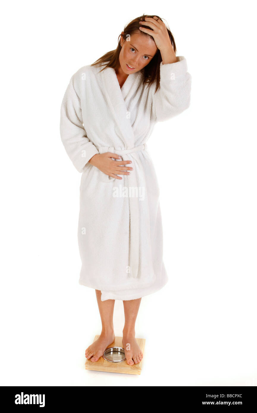 Weibliche wiegen sich auf die Waage im Badezimmer und auf der Suche nach verärgert Stockfoto