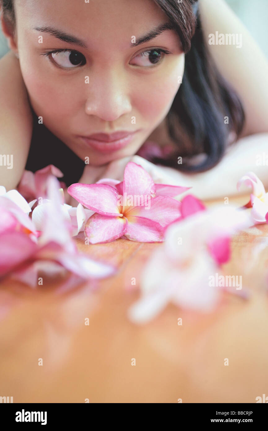 Junge Frau, wegsehen, Blumen vorne auf Ihr Stockfoto