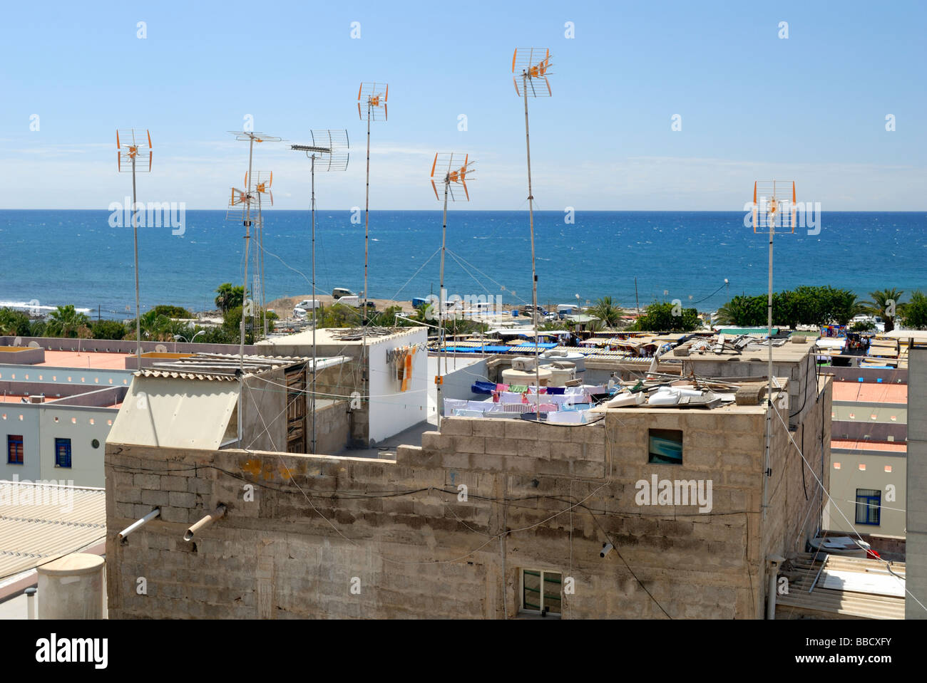 Die Antennen und Wäscheleinen auf dem Dach eines Hauses in der kleinen Küstenstadt Dorf von Arguineguin, Gran Canaria, Kanarische Inseln, S Stockfoto