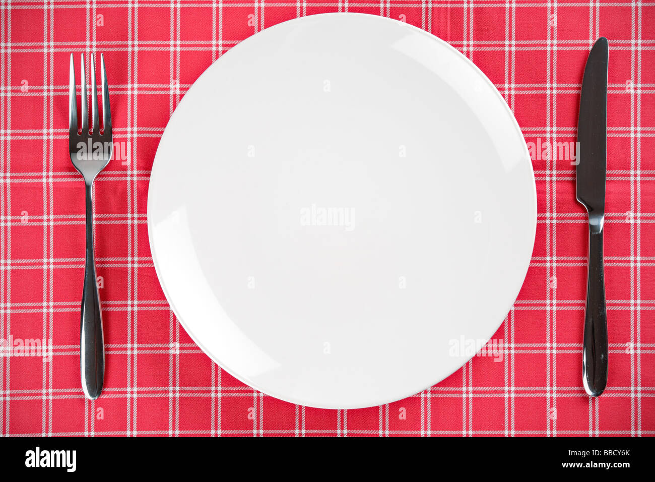 Tischdekoration mit einem leeren Teller und Messer und Gabel Stockfoto