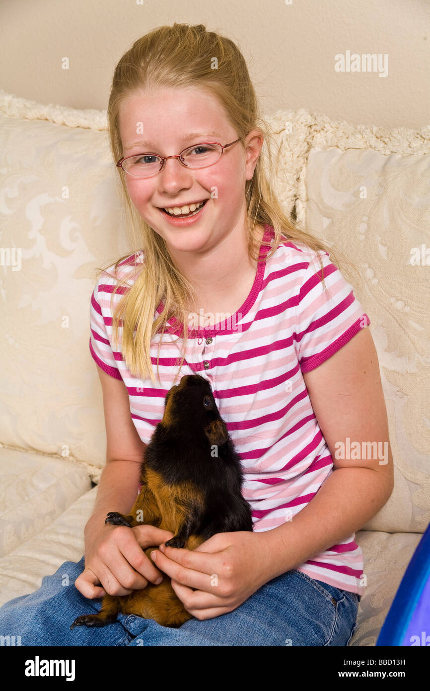 Lachende junge kaukasischen 10 bis 11 Jahre altes Mädchen hält ihr Meerschweinchen Herr © Myrleen Pearson Stockfoto