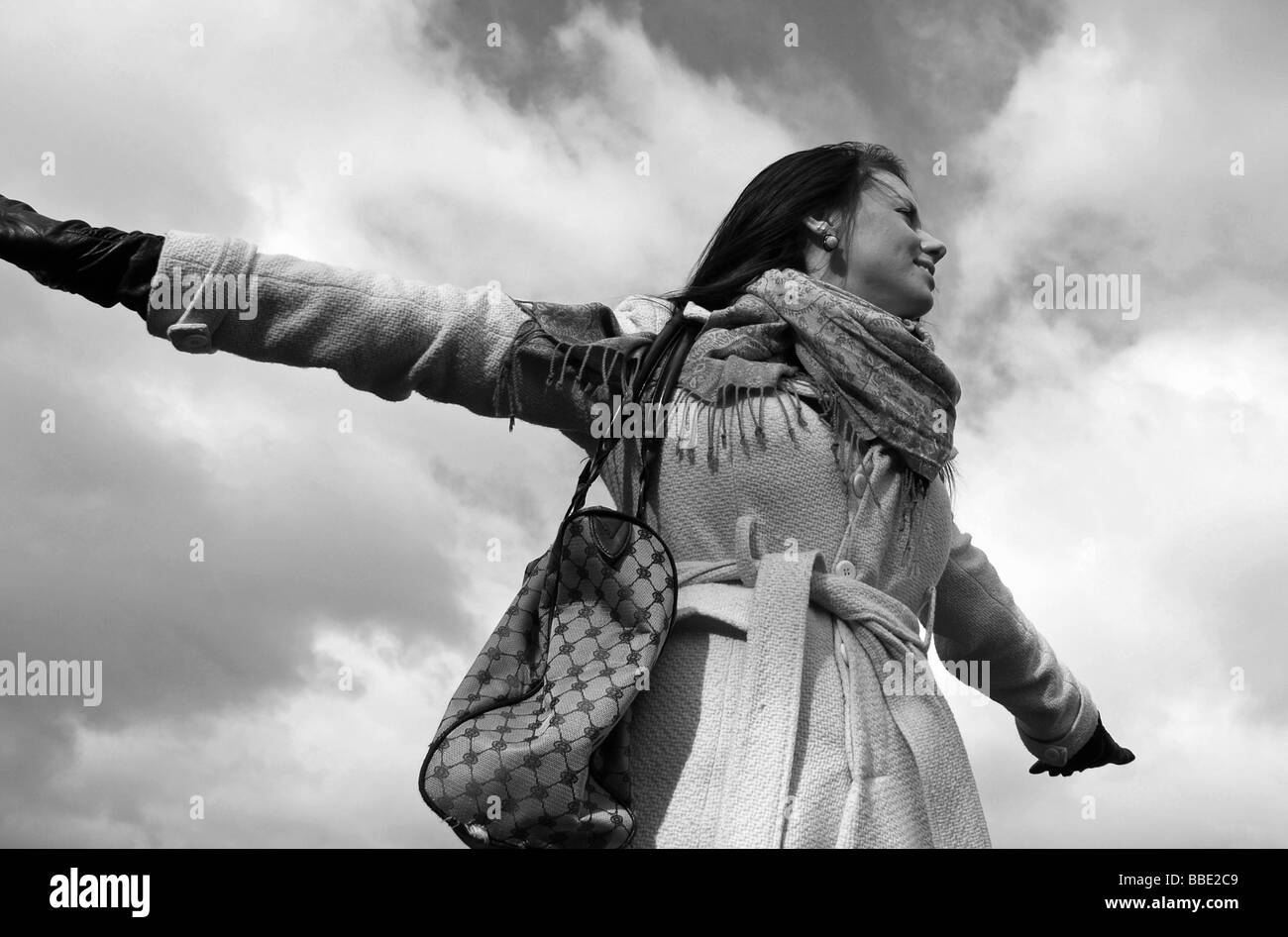 Modell mit gegen den Himmel ausgestreckten Armen Stockfoto
