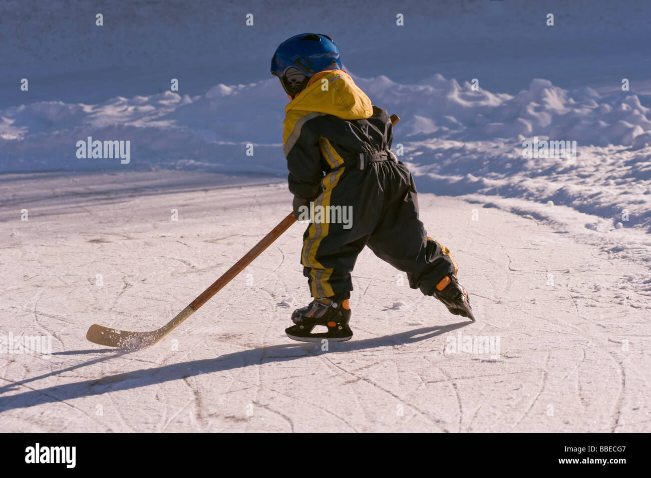 Kleiner Junge spielt Hockey auf einem zugefrorenen Teich, Fuschlsee, Salzburger Land, Österreich Stockfoto