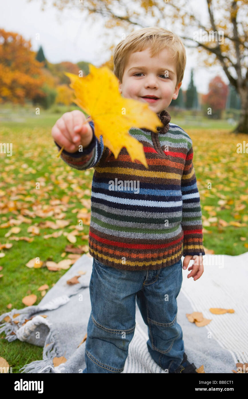 Kleiner Junge hält ein Ahornblatt im Herbst, Portland, Oregon, USA Stockfoto