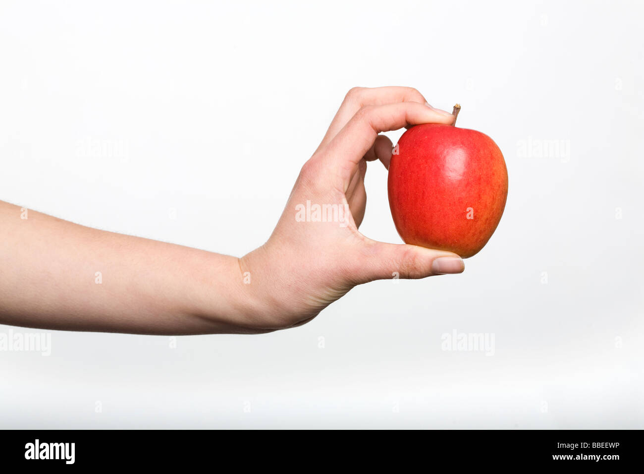 Weibliche Hand hält einen leuchtenden roten Apfel Stockfoto