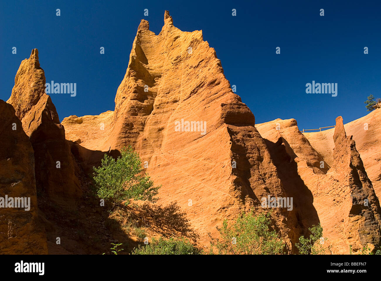 Frankreich, Provence-Alpes-Cote d ' Azur, Vaucluse, Colorado Provençal, erodiert ockerfarbenen Klippe Gesicht gekrönt von gezackten Gipfeln von unten. Stockfoto