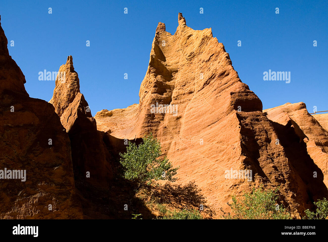 Frankreich, Provence-Alpes-Cote d ' Azur, Vaucluse, Colorado Provençal, erodiert ockerfarbenen Klippe Gesicht gekrönt von gezackten Gipfeln von unten. Stockfoto