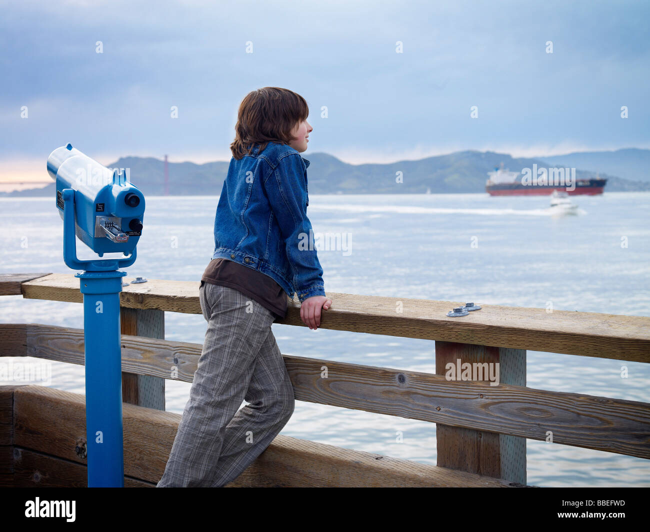 Junge auf der Suche über Wasser vom Pier, San Francisco, Kalifornien, USA Stockfoto