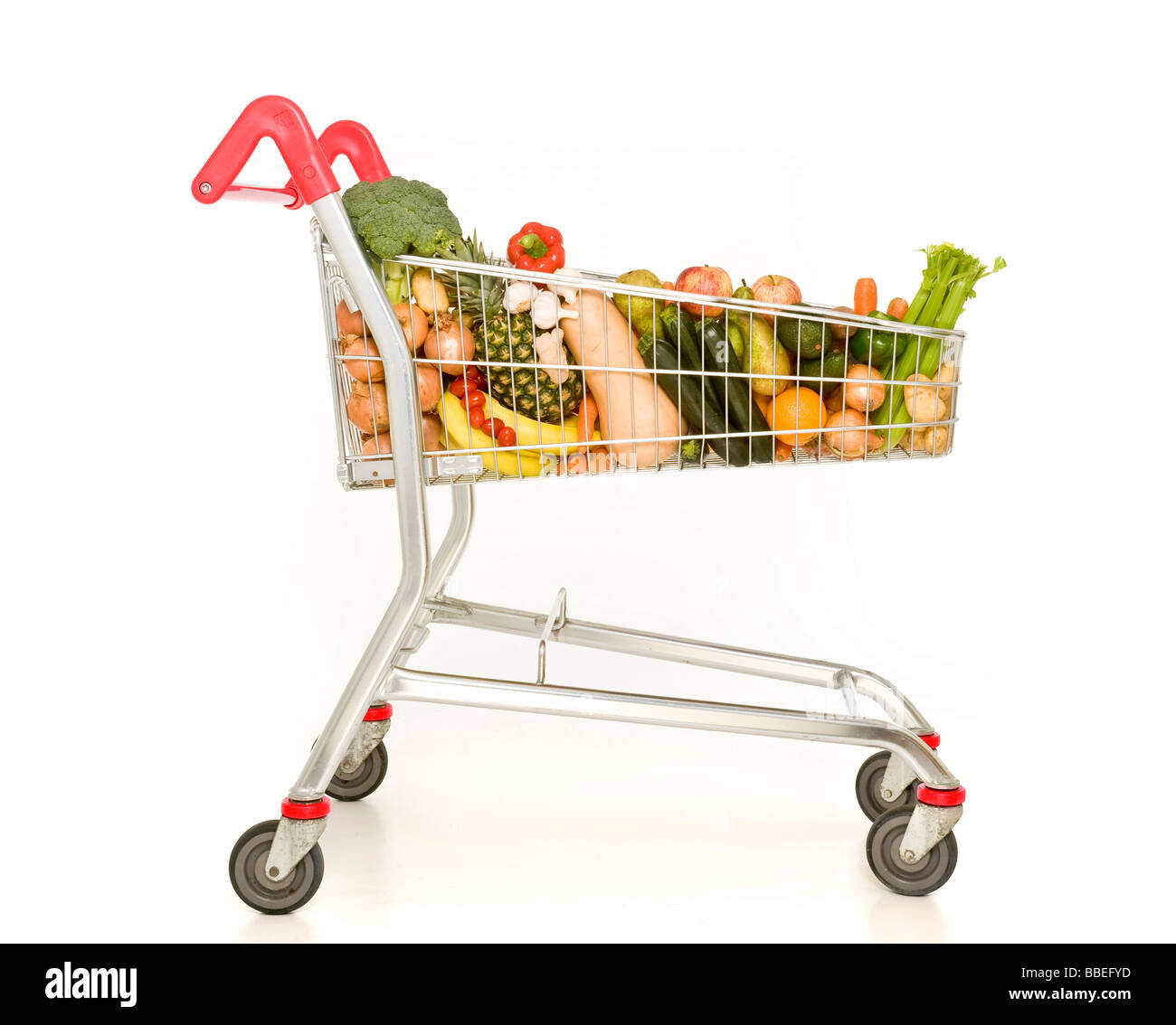 Supermarkt-Einkaufswagen gefüllt mit Obst und Gemüse auf weißem Hintergrund Stockfoto