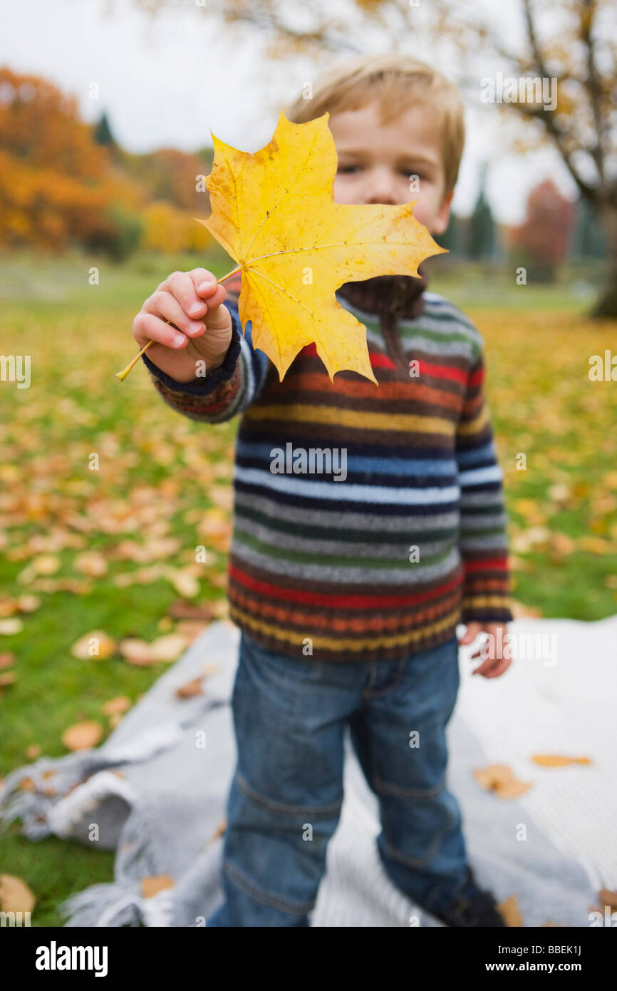 Kleiner Junge hält ein Ahornblatt im Herbst, Portland, Oregon, USA Stockfoto