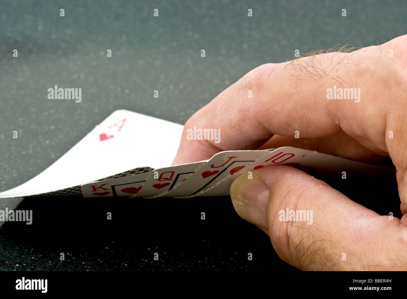 Hand hält eine Hand mit einem Ass der Herzen mit dem Rest der royal Straight Flush nach unten zeigen Stockfoto