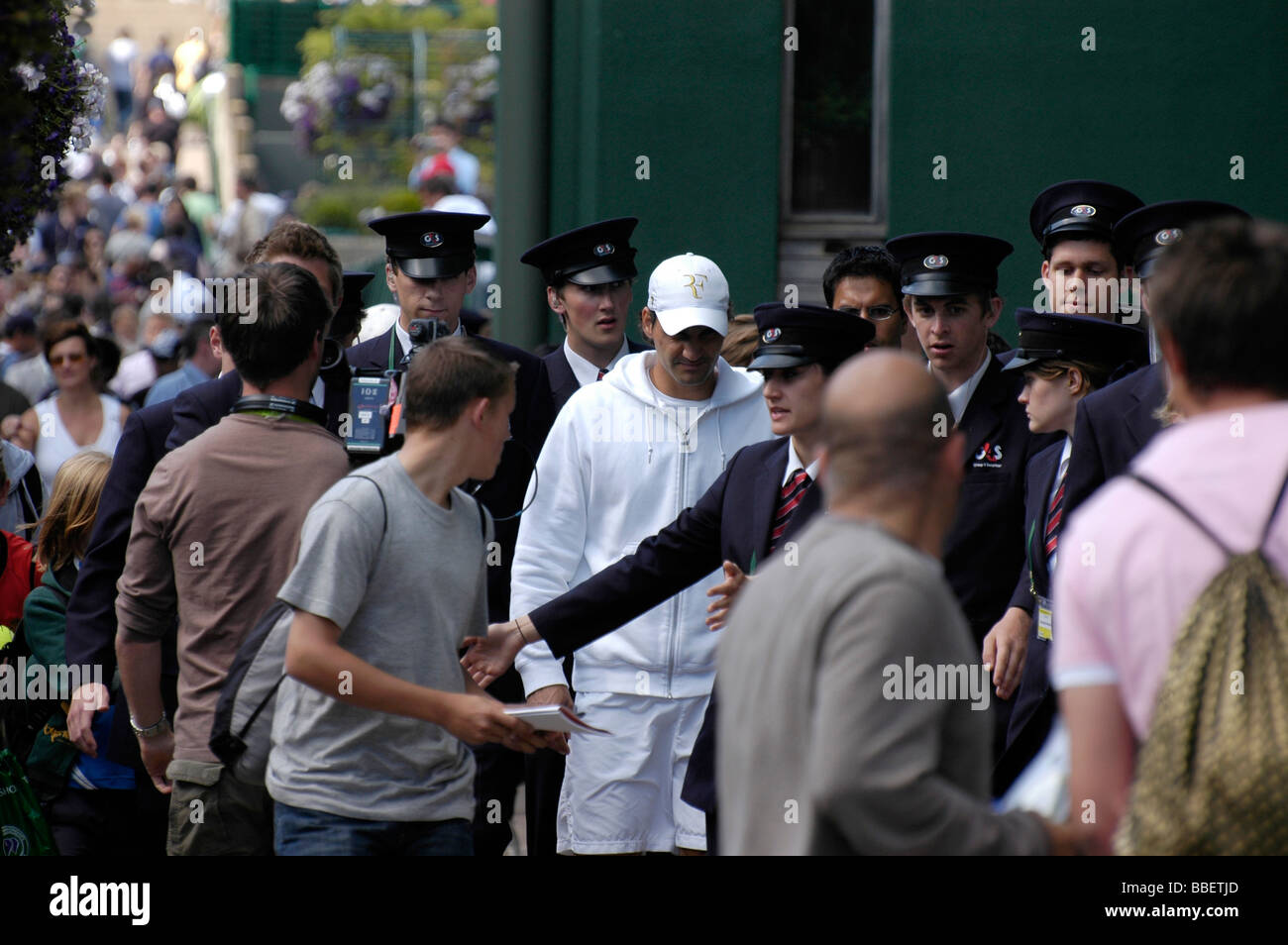 Roger Federrer walking through The All England Club Garden umgeben von Sicherheit und Medien in Wimbledon im Jahr 2008 Stockfoto