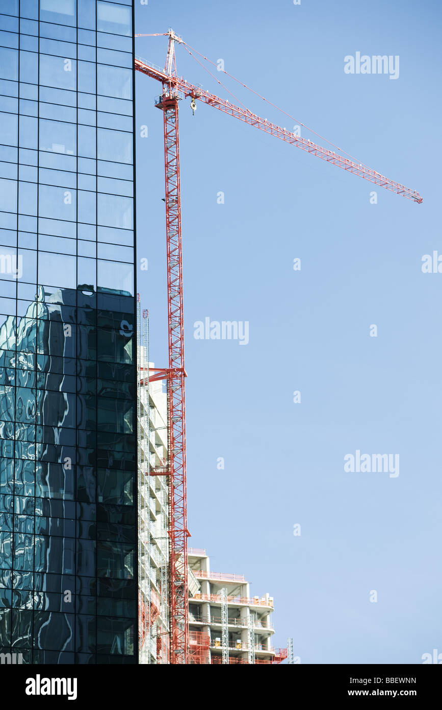 Stahl und Glas hohe Wolkenkratzer, Kran im Hintergrund überragt Gebäude im Bau, beschnitten Stockfoto
